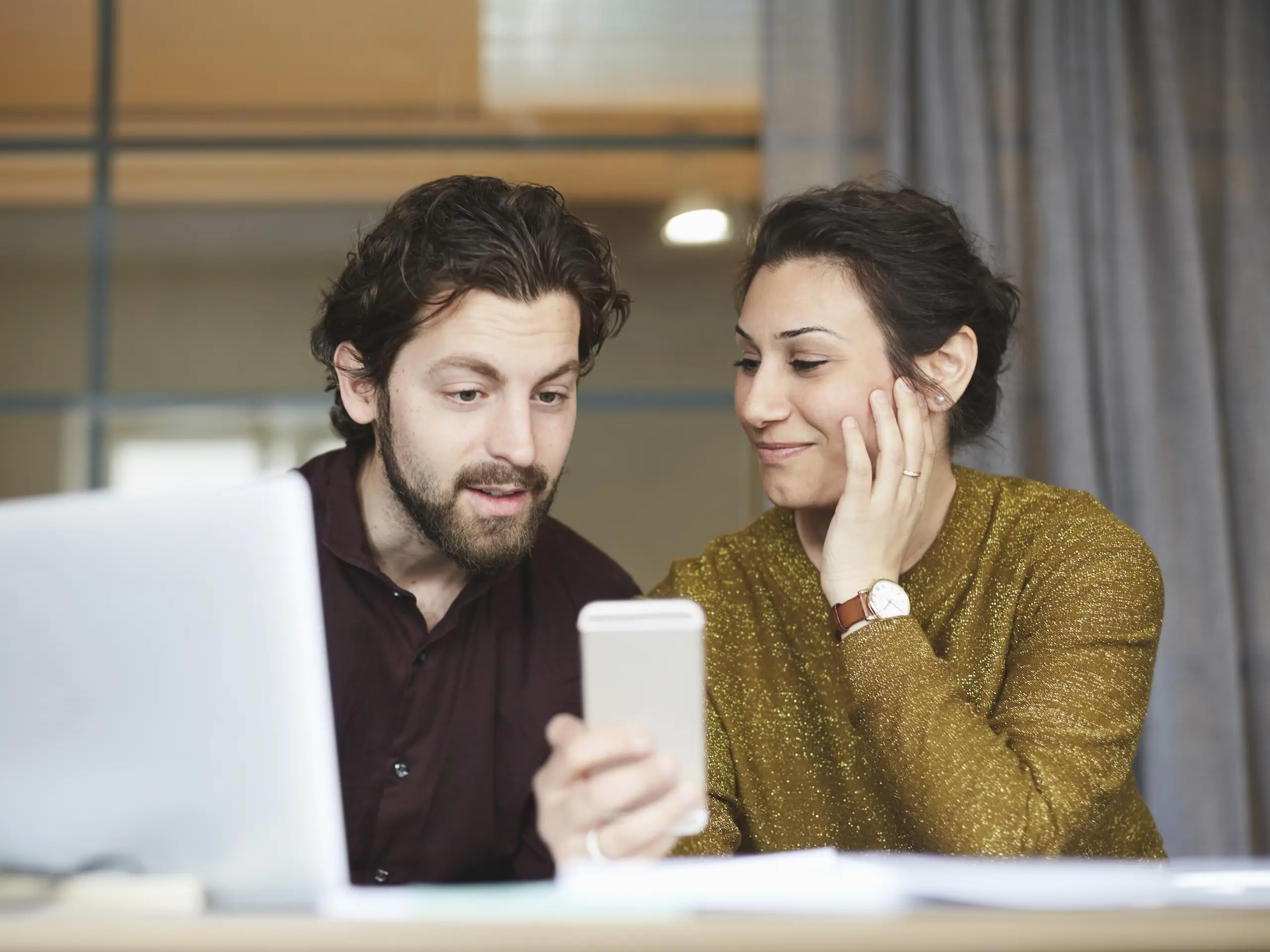 Zwei Personen nutzen Smartphone und Laptop